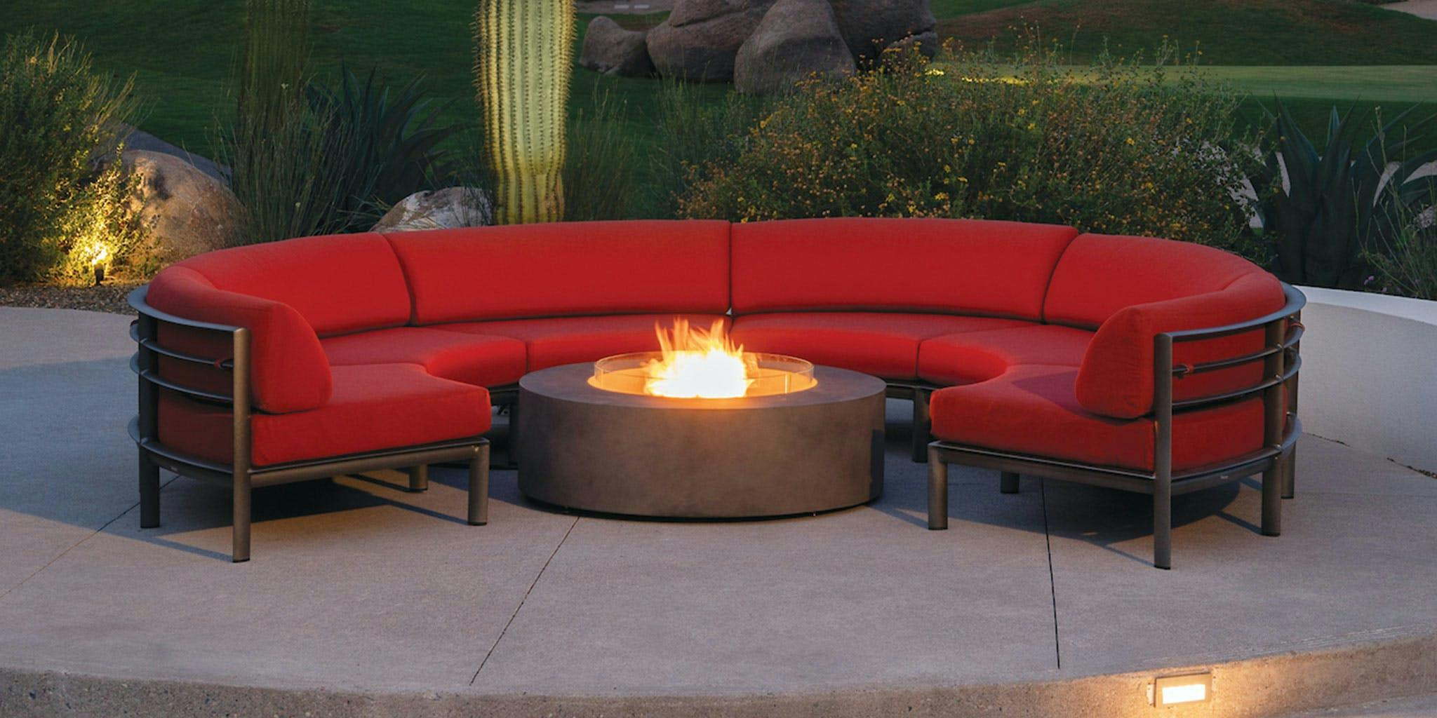modular sofa with red cushions around a fire table
